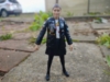 An action figure of Ace from Doctor Who, she is a white teenage girl wearing a black jacket decorated with varous (painted on) pins and patches overa white t-shirt with musical notes, a black skirt, black leggings, and black shoes.