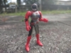 An action figure of SolJeanne. She has a red helmet with a black visor and silver mouthplate. Her torso is predominantly silver with some red and black detailing and a blue circle on her chest. Her arms are red and she also is wearing a red belt across her waist. Her upper legs are silver and black and her lower legs are red.