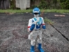 An action figure of Blue Dolphin from Choujuu Sentai Liveman, she is a human female in a full-body costume with a helmet on. Her helmet is modelled after a dolphin and is blue and white with a black visor. Her outfit is also blue and white with a dolphin emblem on her chest. She is wearing blue gloves and boots and is wielding her sidearm, the Liblaster, in her hand