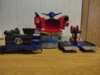 AOTP Star Convoy in base mode, in my own preferred configuration. Differences from the 'official' config are that his robot mode chest is opened to form an additional platform, his head antenna are spread out, his right arm (viewer's left) is transformed into the vehicle mode configuration and facing forward, his left arm (viewer's right) is also transformed into its vehicle mode configuration but rotated back and angled so it's hidden behind him (with his shoulder cannon on that arm angled so the cannons are facing forward in the new configuration), the Micro Trailer battle platform is resting in one of the platforms instead of just in front of it, and his gun is plugged into a port on his rightmost (viewer's leftmost) side
