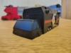 The Micro Trailer! Literally a small all-black truck and trailer with a dark blue windscreen and a red stripe and Autobot chevron on the trailer