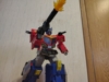 AOTP Star Convoy in robot mode, posed as if he is taking a step forward. We can now see that his thighs are silver and his legs are predominantly blue and yellow, with the sides of the trailer as the sides. He is wielding his gun and a blast effect is inserted into the barrel to give off the illusion of being fired