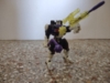 Energon Battle Ravage in robot mode, wielding his tail mace in one hand and his two beast mode guns combined into one gun in his other hand. His gun heavily resembles G1 Megatron's gun mode