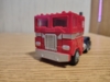 Legacy G1 Optimus Prime in truck mode, a red cab over axle truck with a blue truck bed