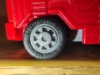 Optimus Prime in truck mode, close up shot of his tire showing the fictional brand 'Cybertron Radial'