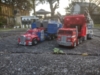 Legacy Armada Optimus Prime in vehicle mode with Legends Super Ginrai in vehicle mode next to it, Legends Super Ginrai is a red truck hauling a grey trailer